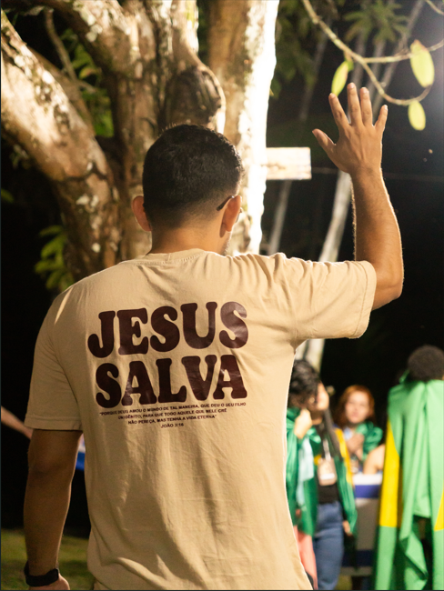 Jovem com camiseta Jesus Salva adorando